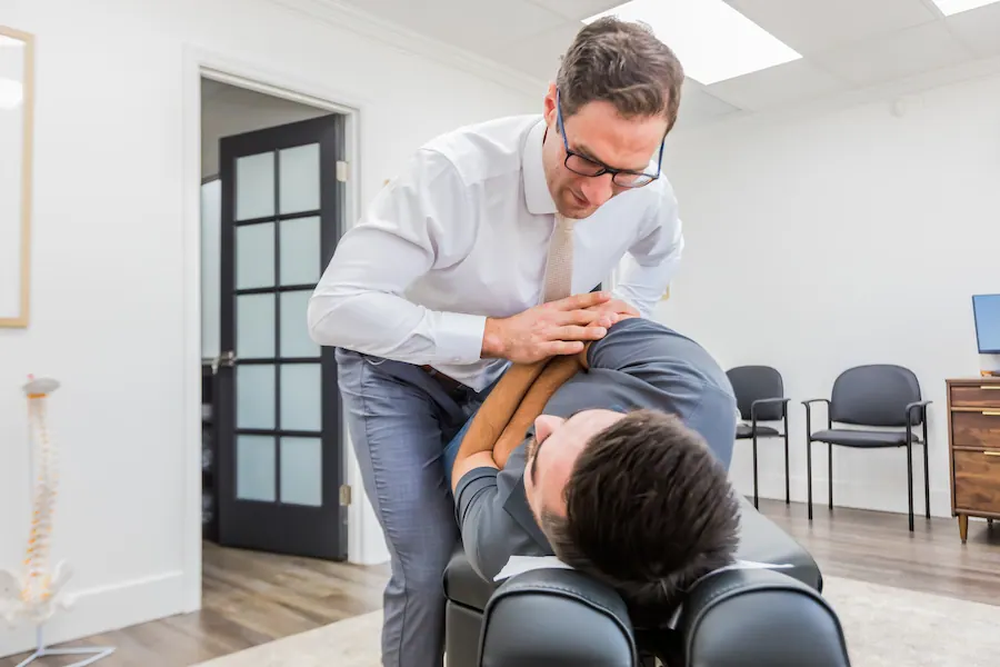 Dr. David Ridos performing chiropractic adjustment on patient