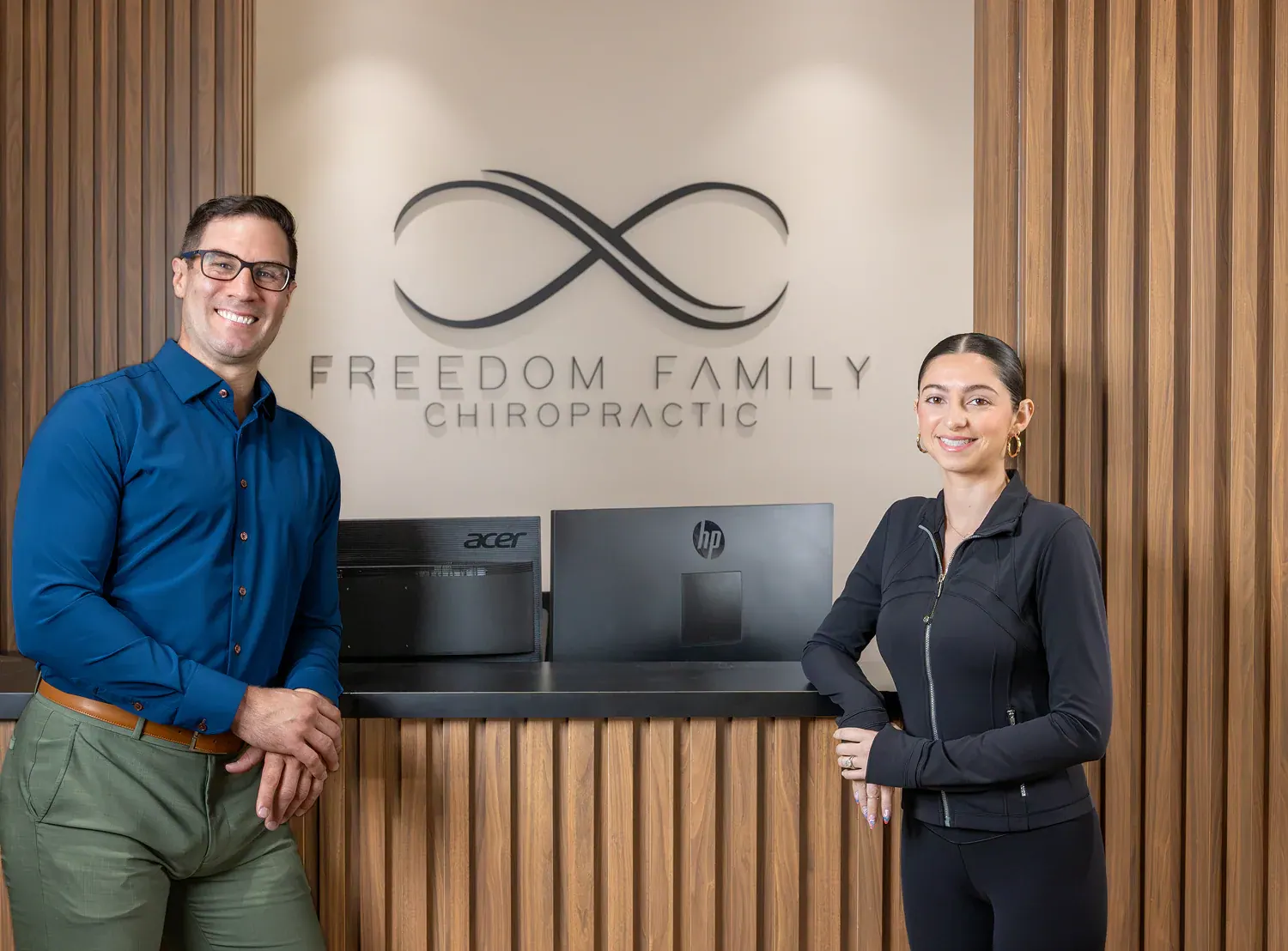 Dr. David Ridos and team member at the Freedom Family Chiropractic front desk