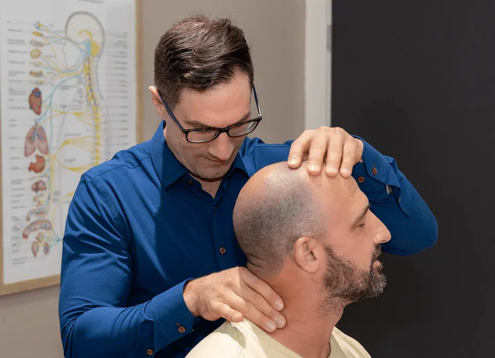 Dr. David Ridos adjusting a patient's neck