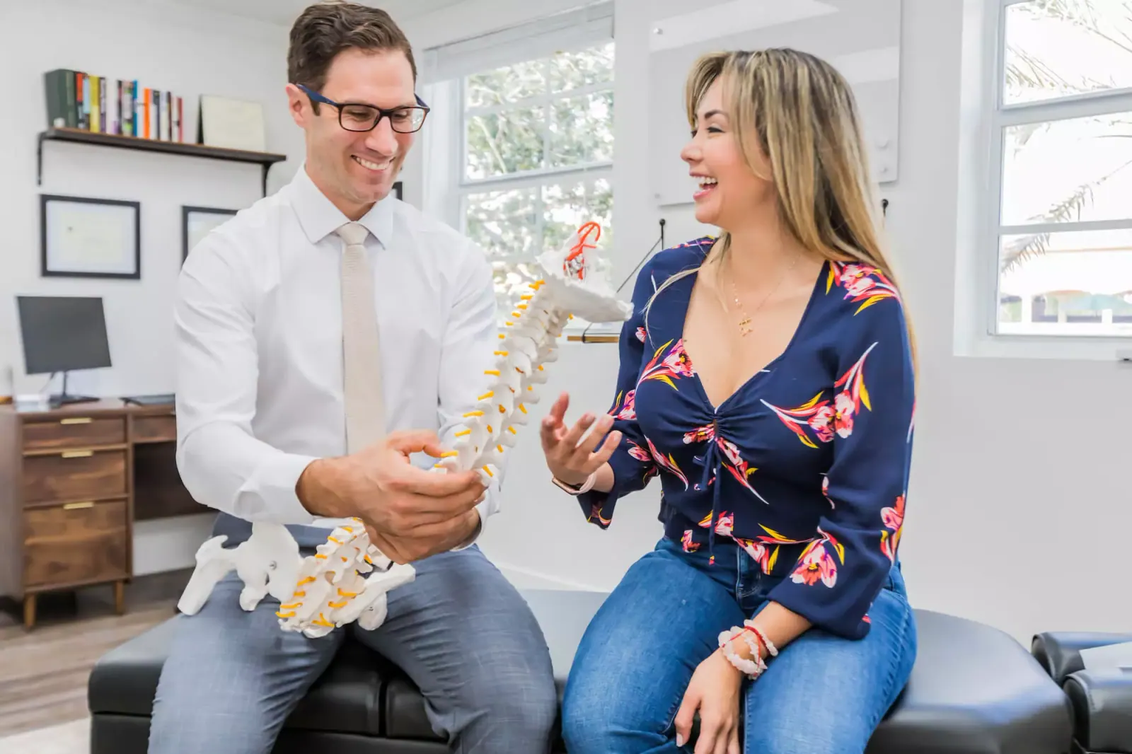 Dr. David Ridos showing a patient a spine model during a consultation